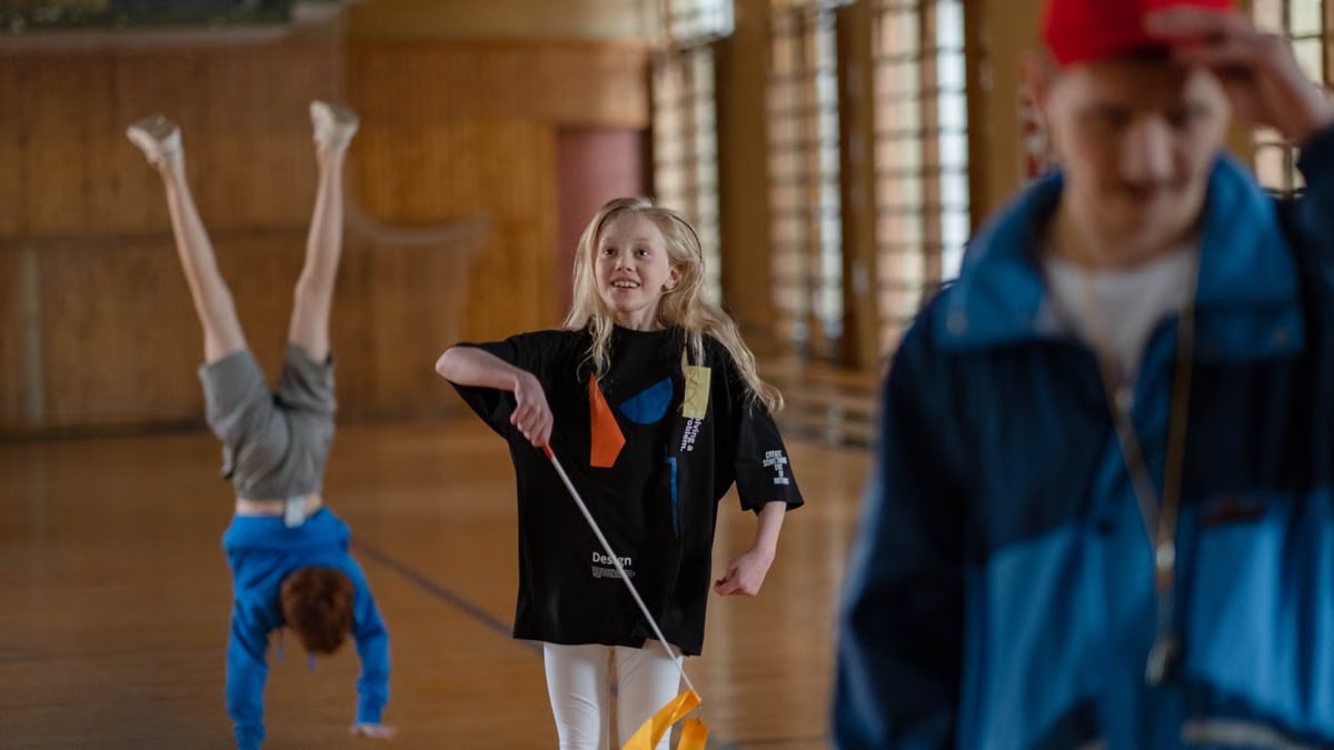 Children having fun in a school gym, with gymnastics and playful activities.
